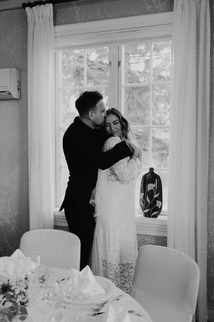 Elegant wedding couple embracing indoors during workshop for wedding photographers.