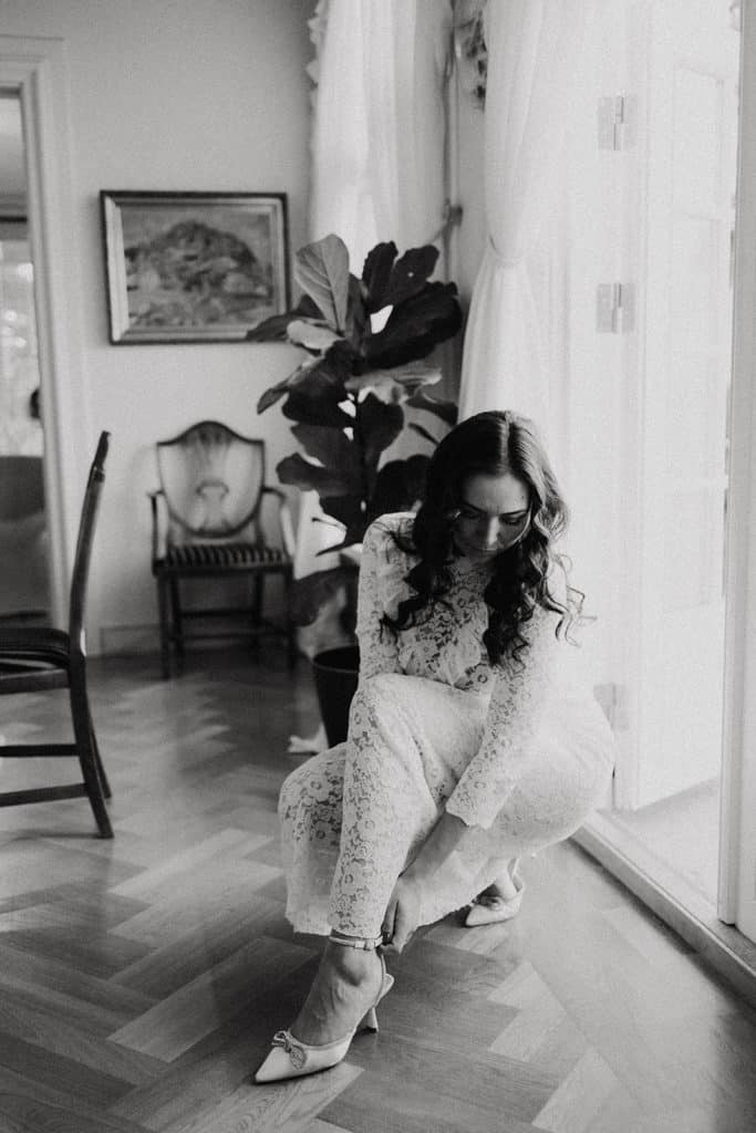 Elegant bride preparing for wedding photoshoot, indoor setting with natural light.