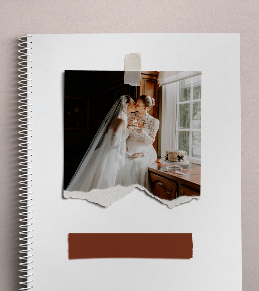 Brides in wedding dresses sharing a kiss indoors.